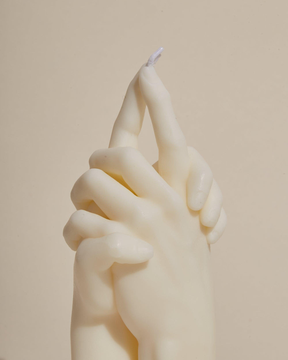 hands holding sculpture white candle