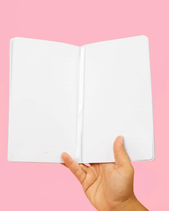 Person holding open adult journal showing interior storage pocket.