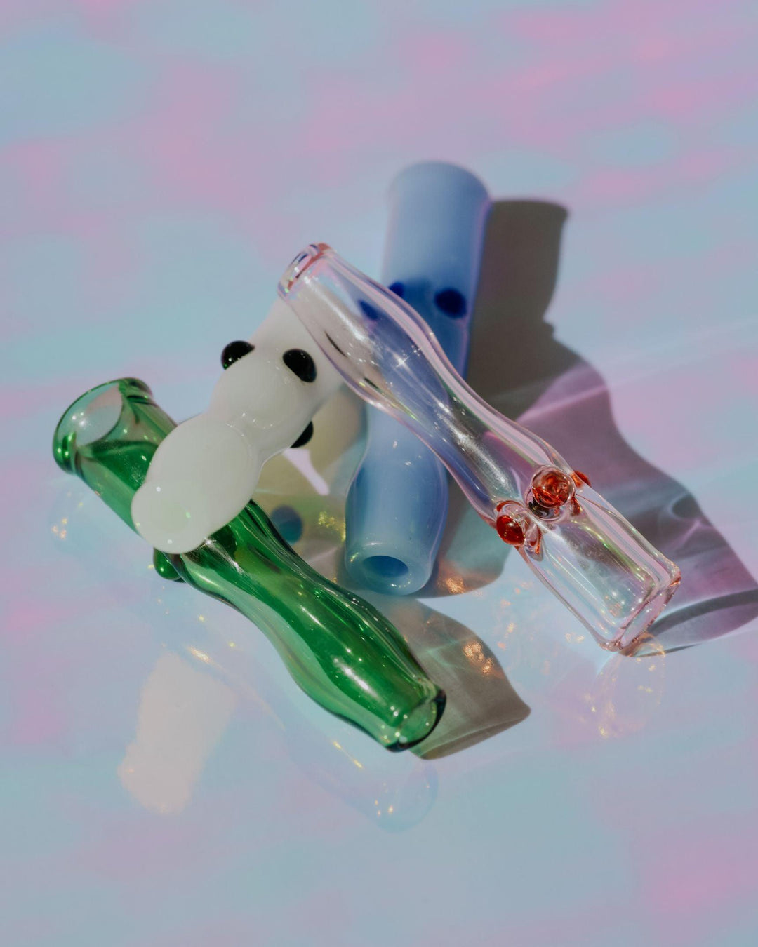 cute glass joint holders in multiple colors, clear green, clear pink, solid white, solid purple.
