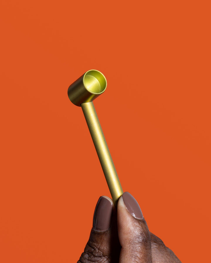 millennial black woman holding gold ti-cobb titanium pipe 