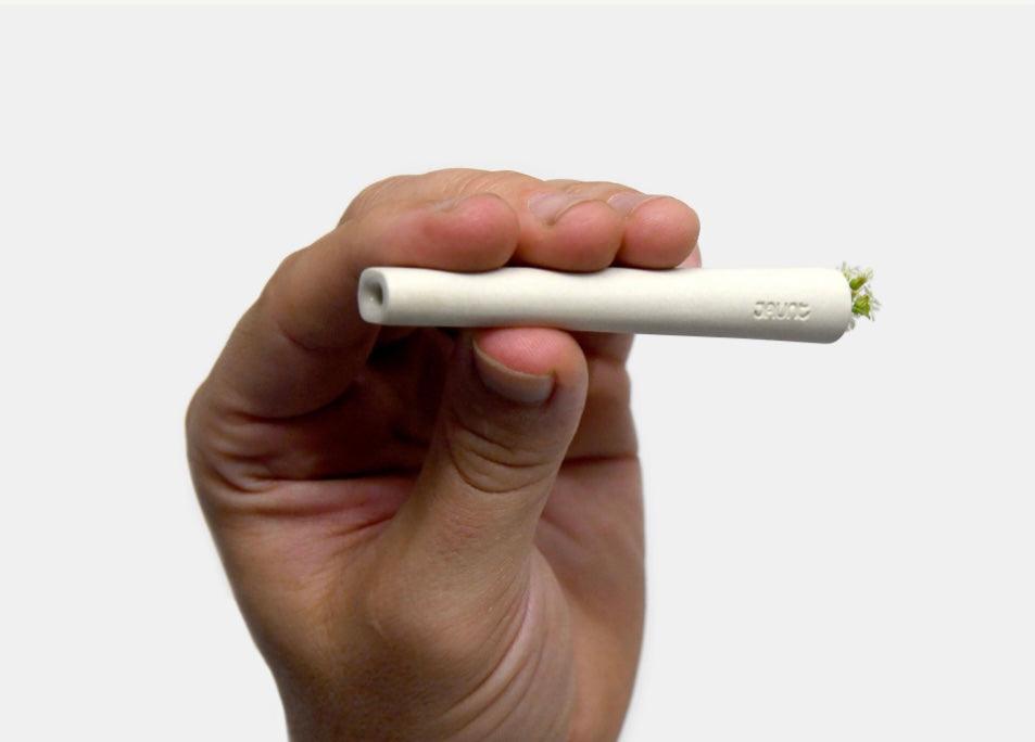Male holding Jaunt ceramic one-hitter in white.